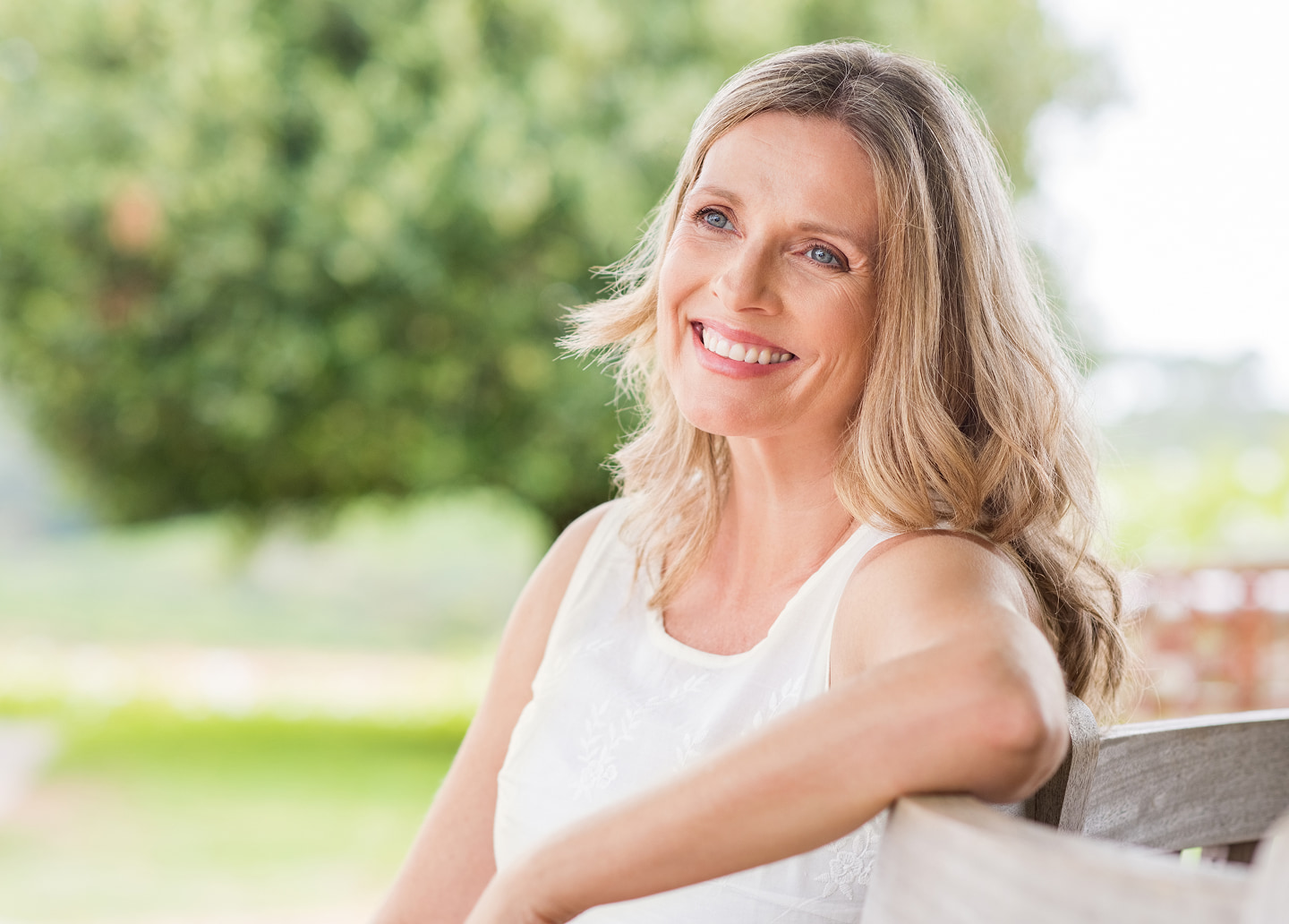 Caring for a new full arch implant smile, emphasizing brushing, water flossing, and regular checkups